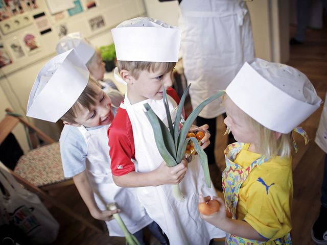 Sarah Wiener Stiftung | photothek Drei Kinder davon eins mit einer Stange Lauch