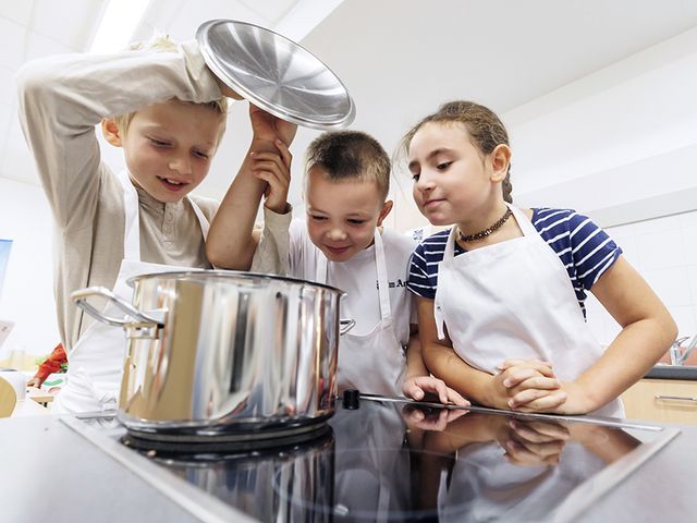 Foto: Sarah Wiener Stiftung I photothek Drei Kinder schauen in einen Kochtopf